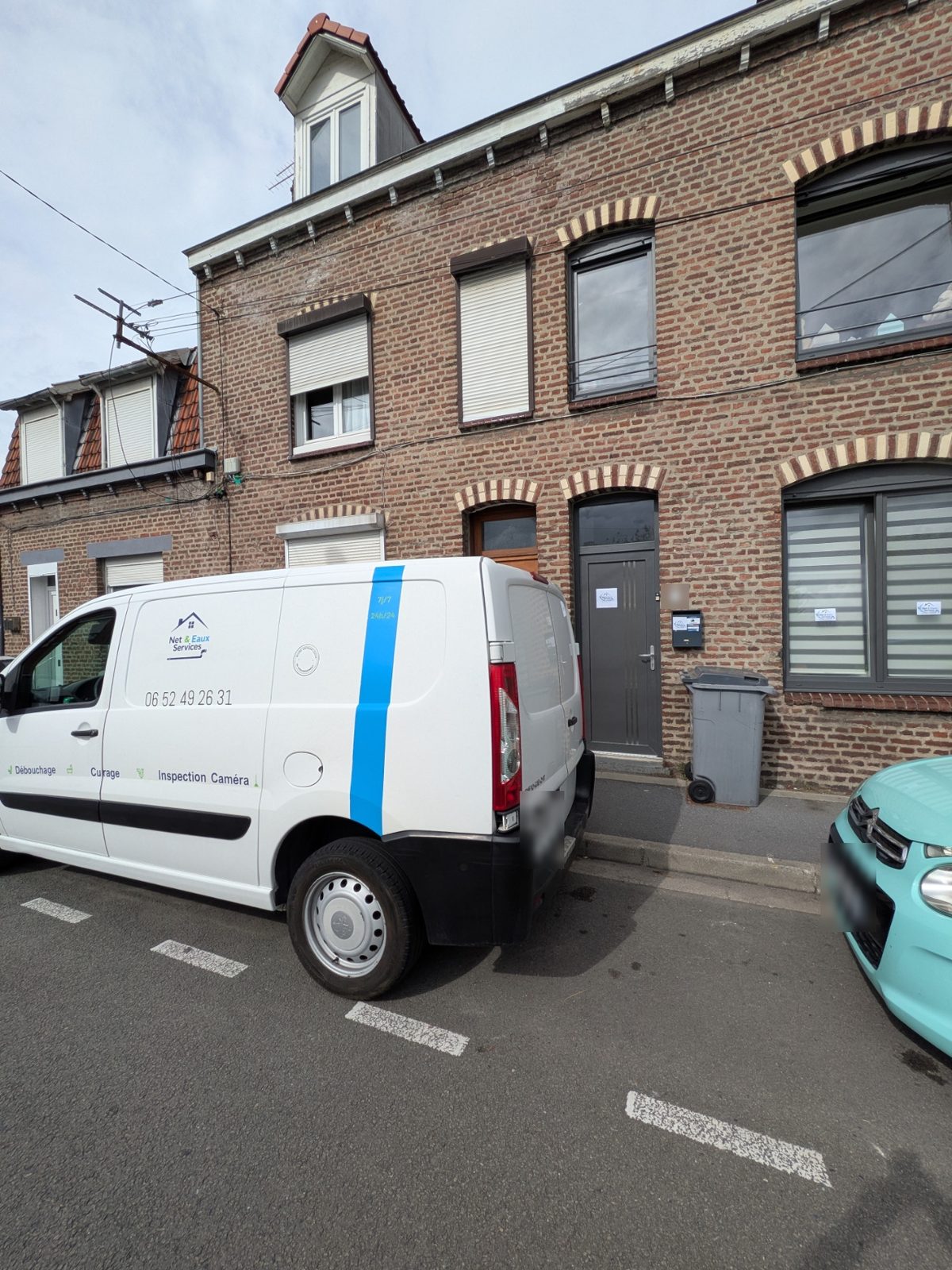 Camionnette Net & Eaux Services devant une maison de ville en brique